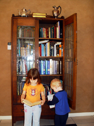 Budding Bookworms Browsing Books Beside Bookcase