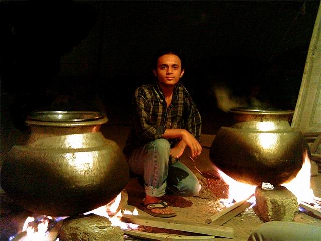 A Boy intrupting the comunication of two gaint bowls on the fire