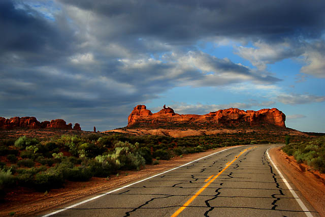 I wish I was driving... on a highway... beneath this graveyard western sky