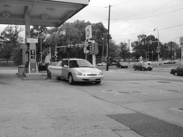 Man Stretching at Gas Station