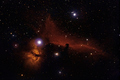 Celestial formations of interstellar gas and dust (Flame and Horsehead nebulae in Orion)
