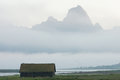 Boathouse and foggy mountain