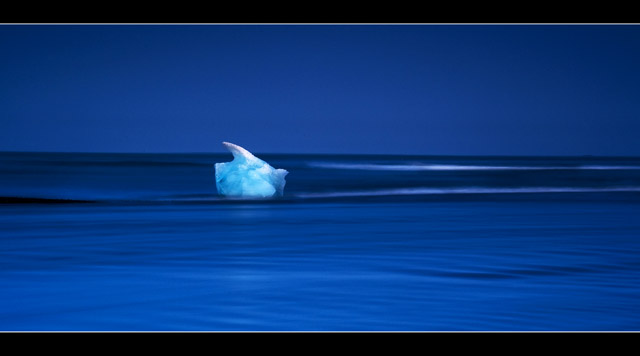 Iceberg Melting on a Smooth Wave  