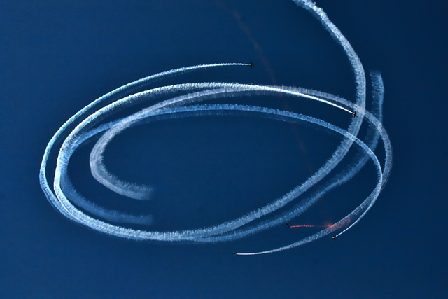 Four airplanes circling a sky diver