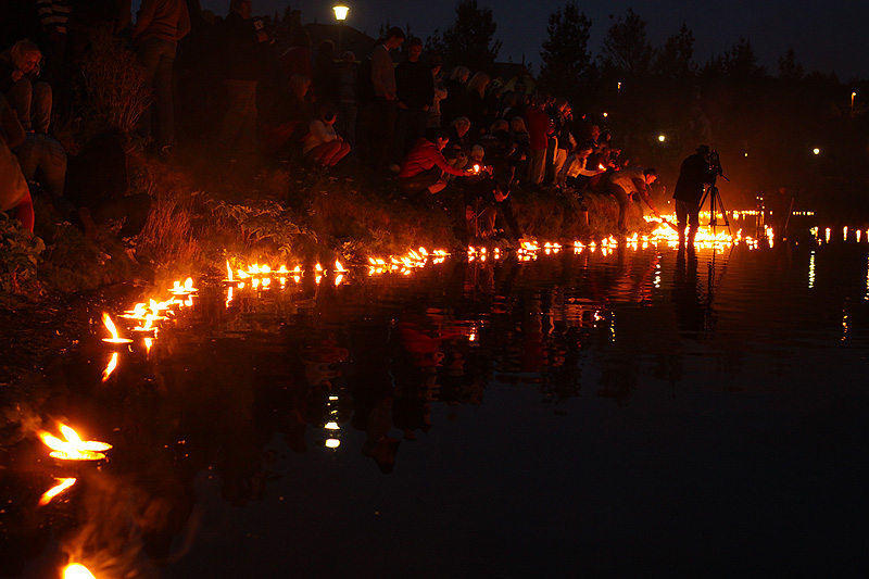 Over black water float the lights of rememberance.