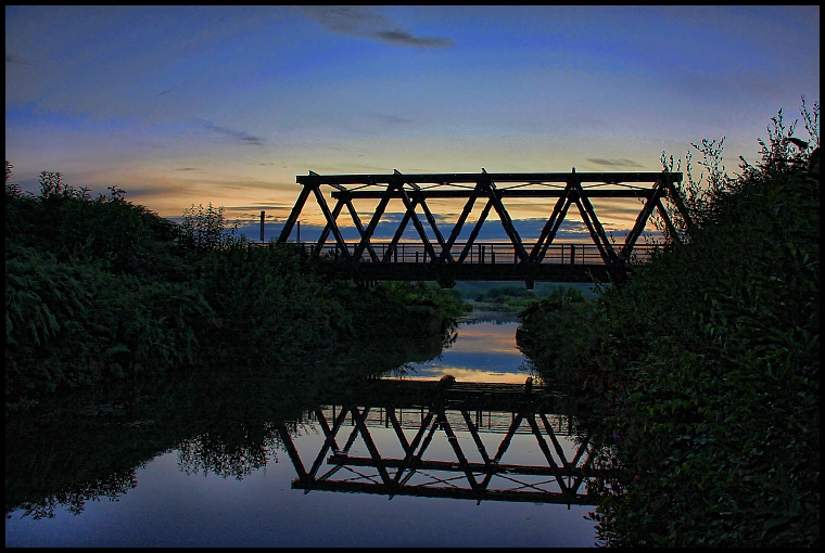 A bridge over calm water.