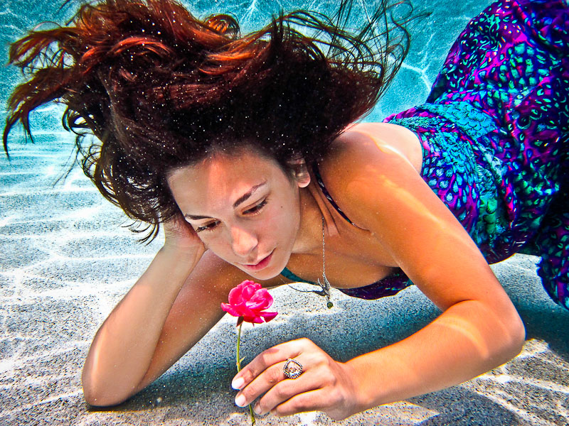 The mystical, underwater beauty was mesmerized by her enchanted rose.