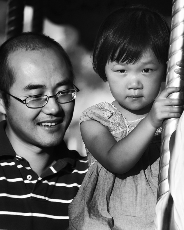 Child, riding the carousel with dad