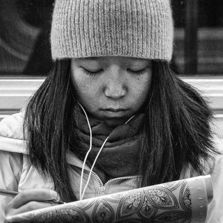 girl with paper and pen on the subway