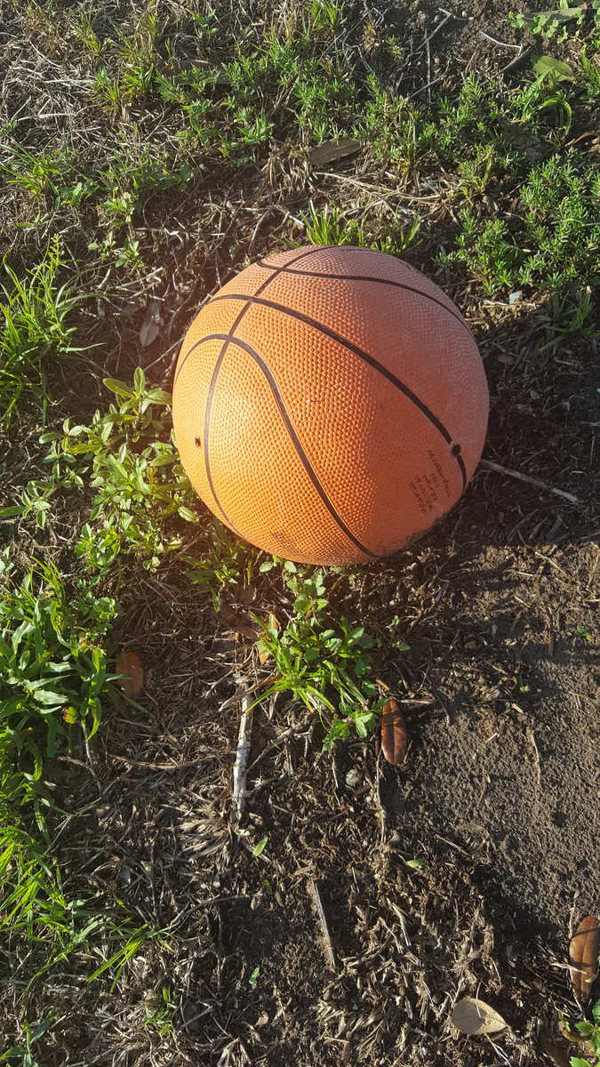 A lone basketball as the sun goes down