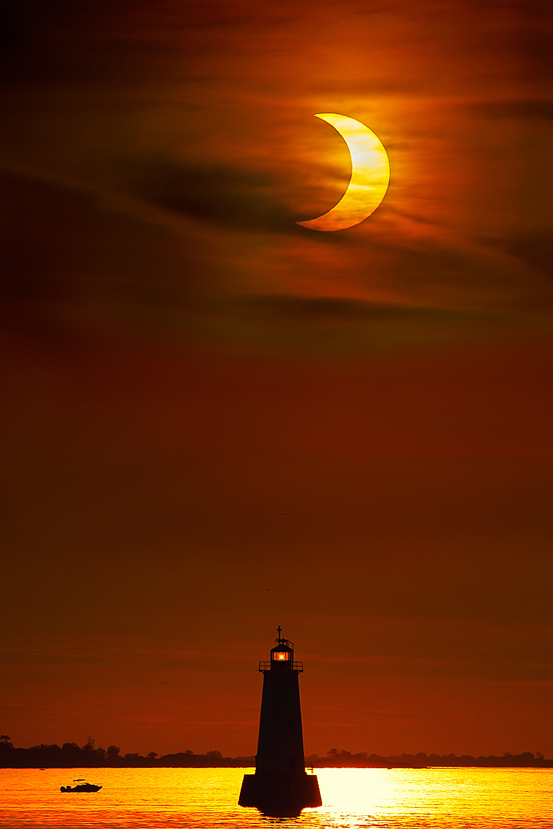 Boating at the lighthouse under the partial eclipse