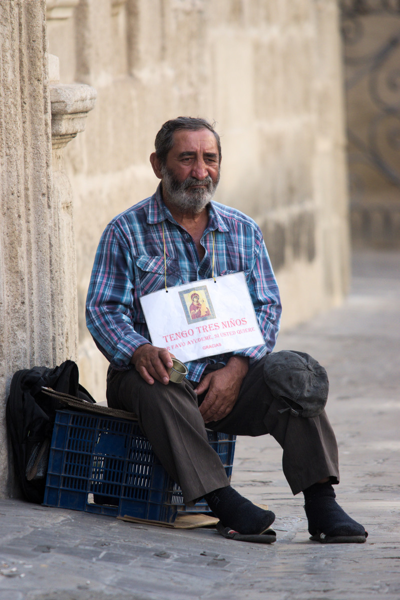 Beggarman asking for alms in the center of Seville