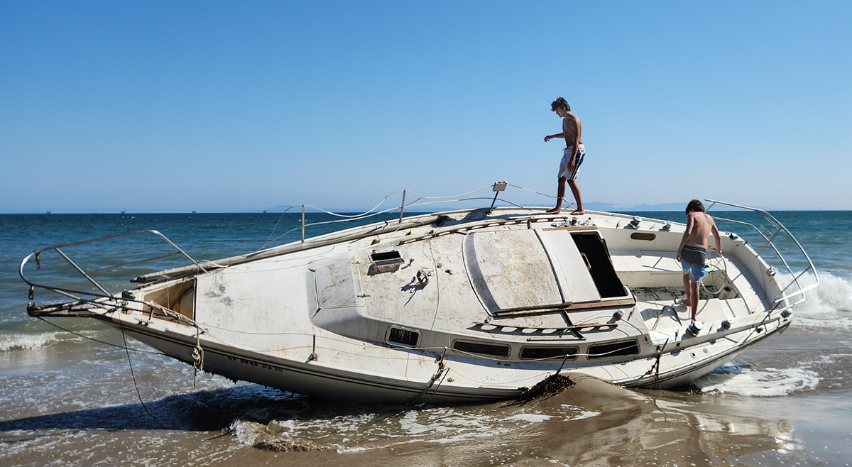 Local kids explore yet another plundered sailboat washed ashore