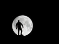 The man stands in front of the moon