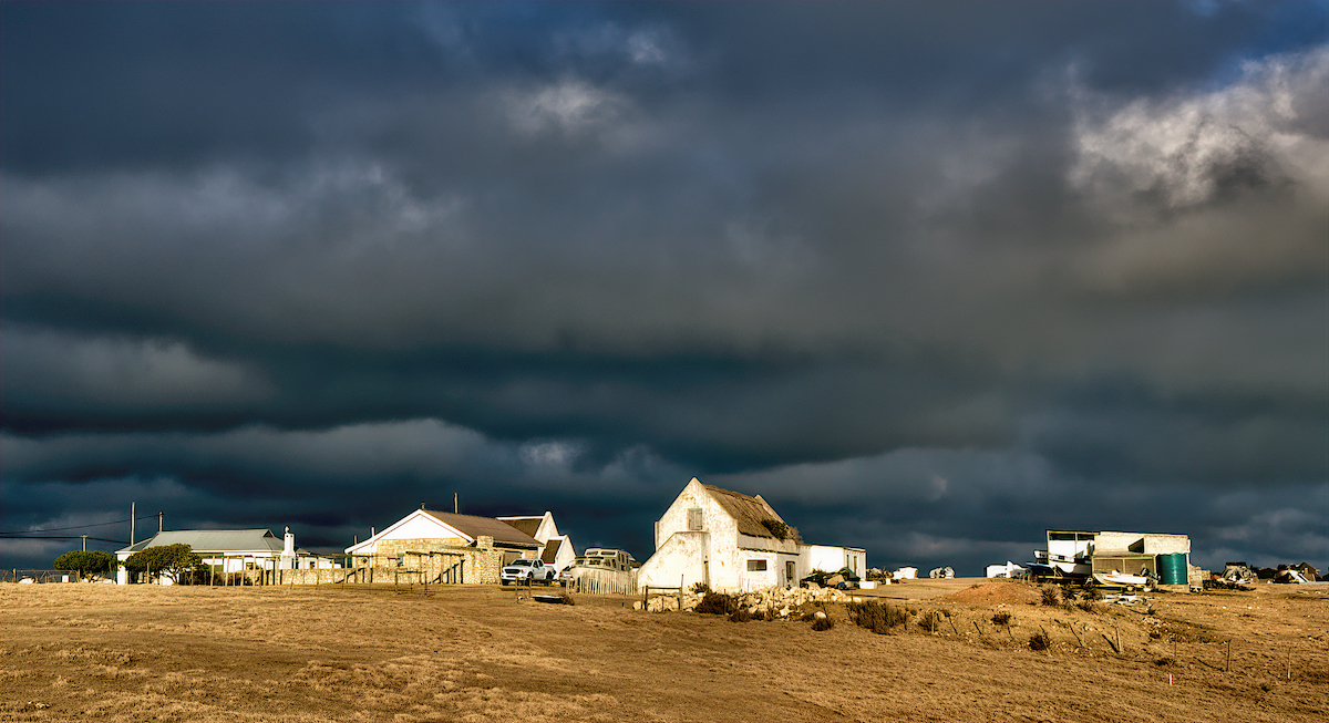 Dark Clouds gather above a Farmstead during Golden Hour 