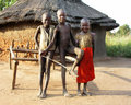 Three Kids In Front of a Hut