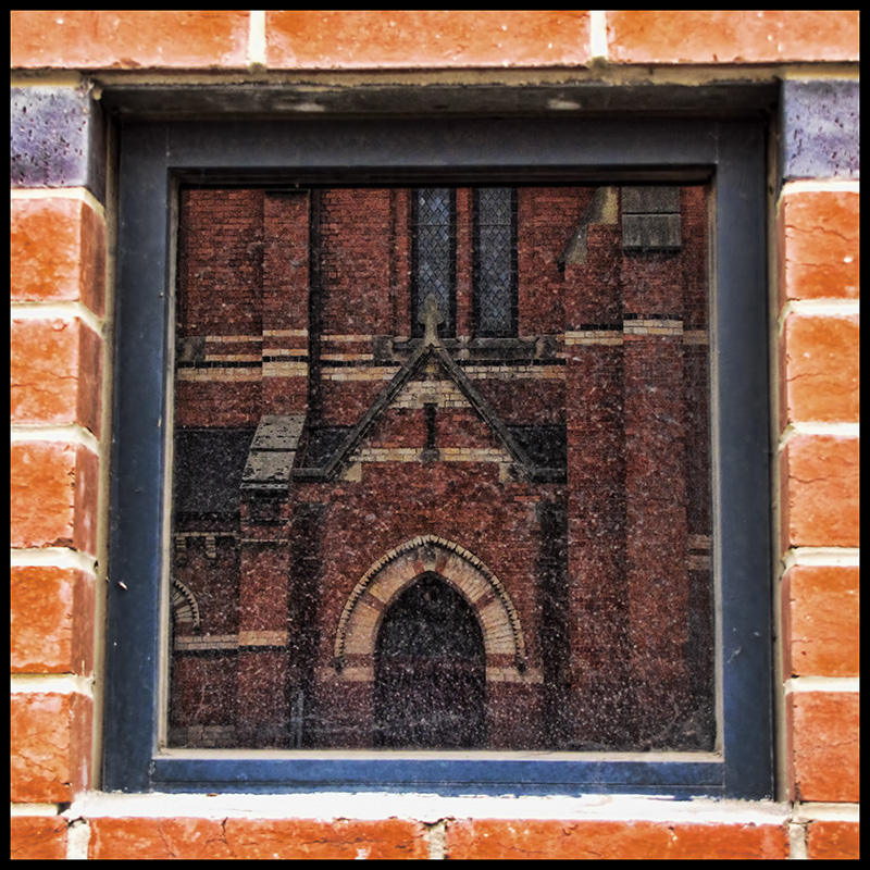 Reflections of Faith in a Dirty Carpark Window